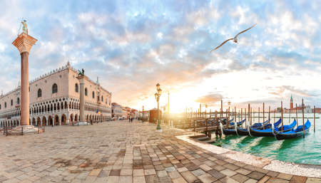 Seagull flies by Doge's Palace and gondolas pier near San Marco Square, Venice, Italy.の写真素材