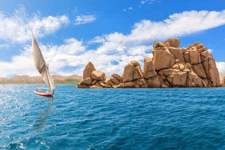 The Nile river, felucca and rocks by the Agilika island, Aswan, Egyptの写真素材