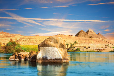 The Nile river and traditional ancient rocks on the way to pyramids, Aswan, Egypt.の写真素材