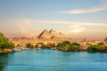View on the Nile and the boats at sunset in the Aswan desert near the Pypamids of Egypt.の写真素材