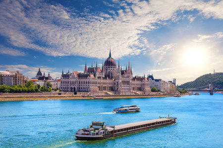 Scenic view of the Parliament of Hungary and Danube River cruise ships under dramatic evening sky, Budapest.の写真素材