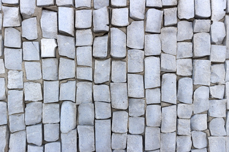 Light blue smalt pebbles on gray cement wall.の写真素材