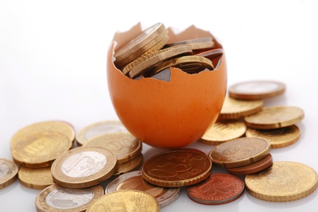 coins in an eggshell, metaphor for financial savings,fragile financials,...........