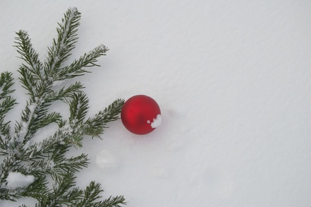 a red bauble in snowy winter landscapeの写真素材