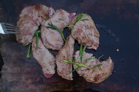 deer meat on bbq flagstone with rosemary