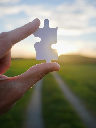 Pinch a piece of the jigsaw puzzleの写真素材