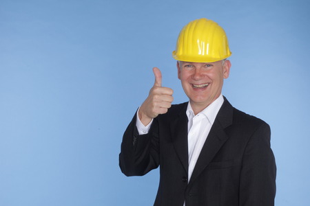 an architect is smiling in front of a blue backgroundの写真素材