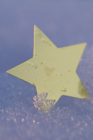 golden christmas symbol in real snow surfaceの写真素材