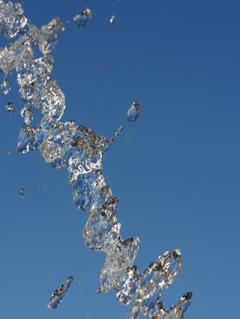 Water splash stream against blue skyの写真素材