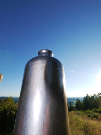 Metal water bottle in a green summer forestの写真素材