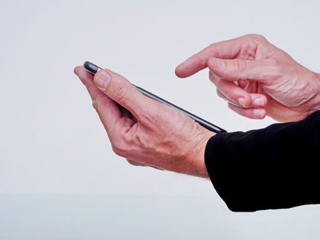 Close up of man using mobile smart phone isolated on white backgroundの写真素材