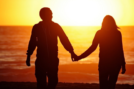 A couple on the beach with sunset background