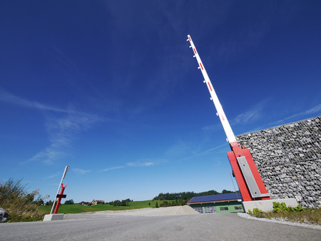 A red stop sign on a barrier and a big blue sky.の写真素材