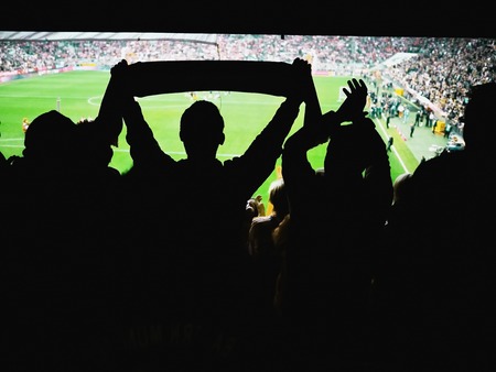 Crowd of footbal supporters and fans cheer at the stadium.の写真素材