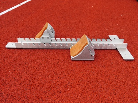 Athletics Starting Blocks on a red running track in a stadionの写真素材