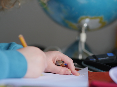 child hands of primary school boy writingの写真素材
