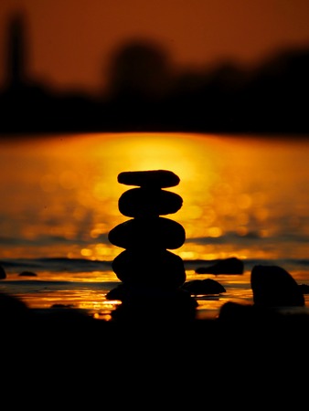 stapled stones in front of a lake in sunsetの写真素材