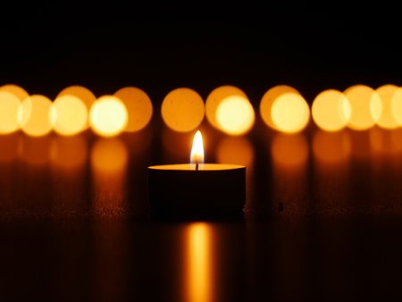 One candle flame at night with bokehの写真素材