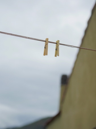 two plastic clothes-pegs on rope against of cloudy sky.Low perspective.の写真素材