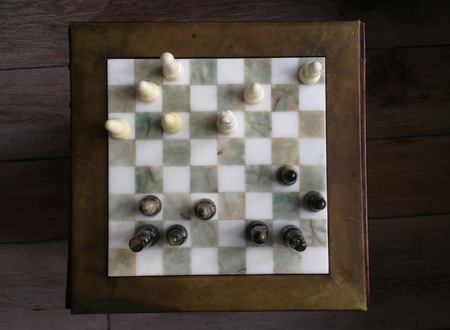 Chess pieces on old wooden table. Top view.