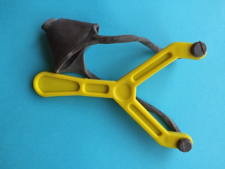 Yellow toy catapult on blue background. From above.の写真素材