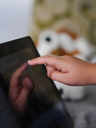 child on the floor using tablet close-up of handの写真素材