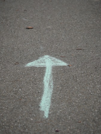 arrow of chalk painted on asphaltの写真素材