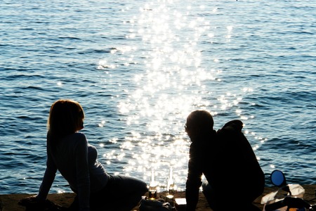 shillouettes of people a strolling at the beachの写真素材