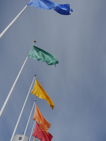 Flags of different colors on flagpolesの写真素材