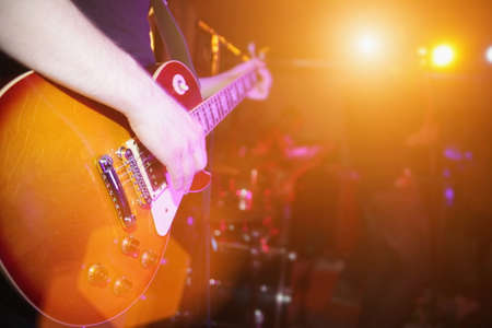 Artist playing the guitar while performing live