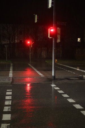 A street with two traffic lights and a wet road