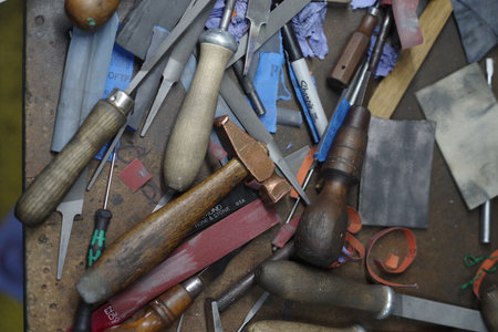 Table full of woodworking tools, including hammers, pliers, and knives