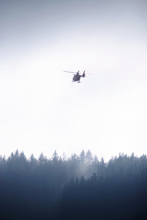 Helicopter is flying over a forest