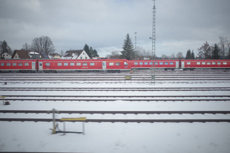 Red train is parked on a snowy track