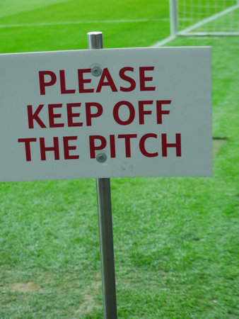 Sign on a green field that says "Please keep off the pitch."の写真素材