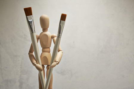 Wooden mannequin with paintbrushの写真素材