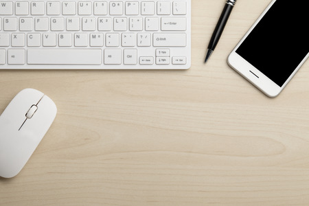 Modern working business desk with keyboard, pen, smart phone & mouse. Top view with copy space