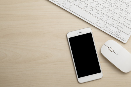 Modern working business desk with keyboard, smart phone & mouse. Top view with copy spaceの写真素材