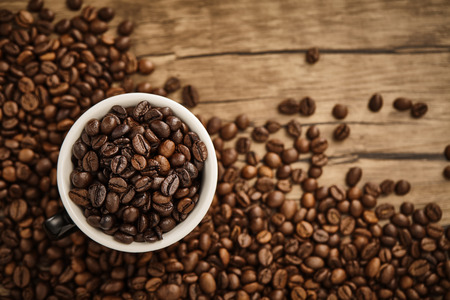 Cup of coffee beans with wooden table