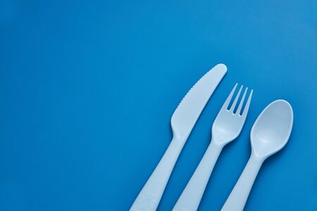 Plastic blue cutlery set with blue background. Top viewの写真素材