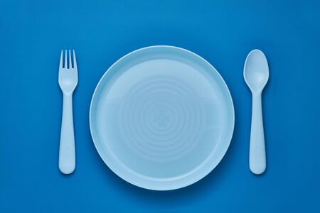 Plastic blue cutlery set with blue background. Top viewの写真素材