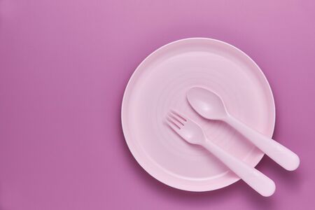 Plastic purple cutlery set with purple background. Top viewの写真素材