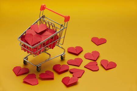 Trolley with red heart on yellow background, top view with copy spaceの写真素材