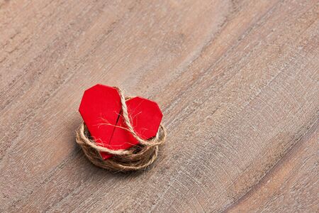Tied up red heart on wooder table background, top view with copy spaceの写真素材