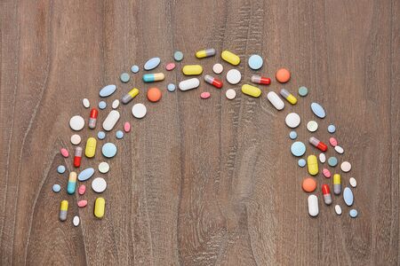 colorful tablets and capsules on wooden background. Health care conceptの写真素材