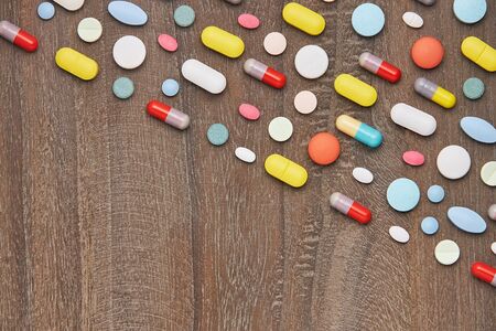 colorful tablets and capsules on wooden background. Health care conceptの写真素材