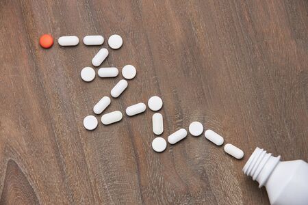 Bottle colorful tablets and capsules on wooden background. Health care conceptの写真素材