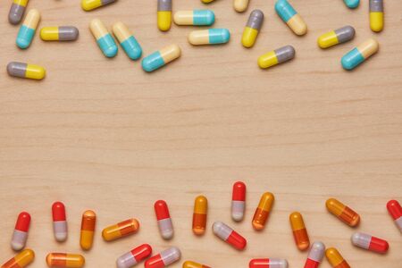 colorful tablets and capsules on wooden background. Health care conceptの写真素材