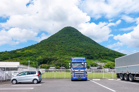 Mount Iino, also known as Sanuki Fuji, can be seen behind a large truck (Marugame City, Kagawa Prefecture)の写真素材