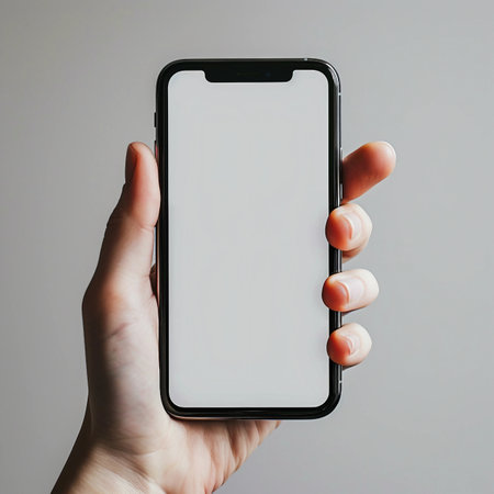 male hand holds a phone with a white screen on a gray backgroundの素材